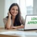 Smiling borrower checking loan approval message on laptop